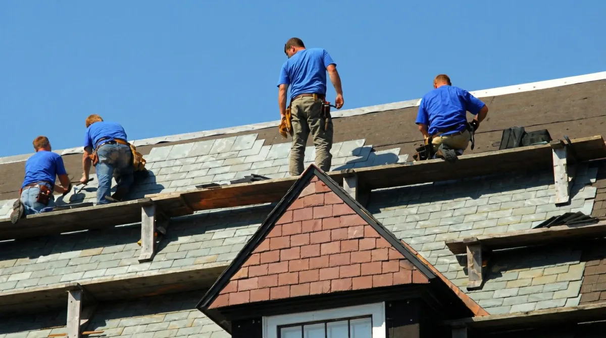 Roof replacement in progress with a team of professional contractors installing new shingles on a residential home in Ogden, UT